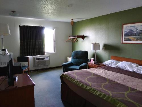 ein Hotelzimmer mit einem Bett und einem Stuhl in der Unterkunft Amerihost Inn & Suites in Kingdom City