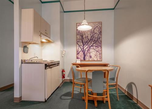 a kitchen with a table and chairs in a room at The Cedars Inn Hotel & Convention Centre in Gibsons