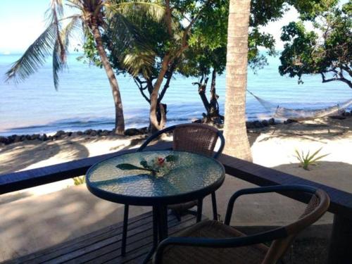 a table and chairs on a balcony overlooking the beach at Funky Fish Beach & Surf Resort in Malolo