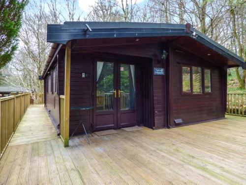 a building with a wooden deck with a large door at Top Lodge, 4 Skiptory Howe in Windermere