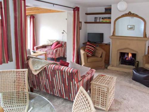 a living room with two couches and a fireplace at Hour Cottage in Stow on the Wold
