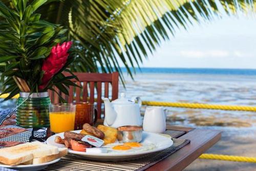 a breakfast plate of eggs and toast on a table by the beach at Funky Fish Beach & Surf Resort in Malolo