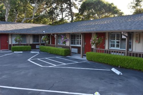 a red building with a parking lot in front of it at Padre Oaks in Monterey