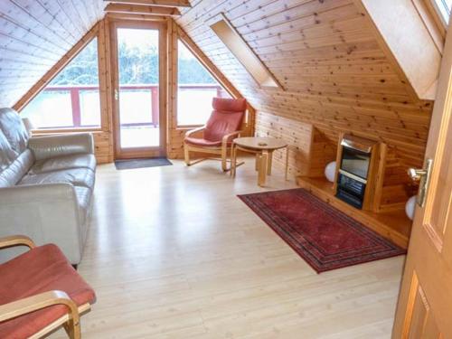 a living room with a couch and chairs in a cabin at Strathavon Chalet in Aviemore