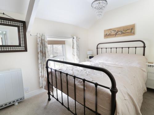 1 dormitorio con cama negra y espejo en 19 Cwmorthin Road, en Blaenau Ffestiniog