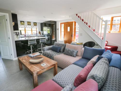 a living room with two couches and a table at Woodstock Lodge in Broadwas