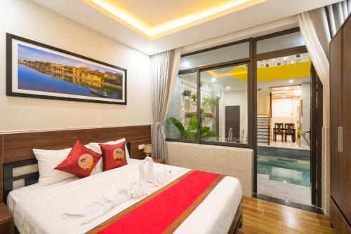 a bedroom with a bed and a large window at The Lit Villa Hoi An in Hoi An
