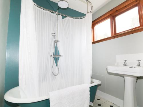 a bathroom with a shower curtain and a sink at Annfield in Aberlour