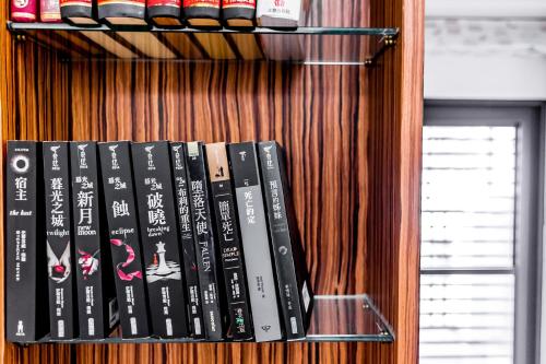 a bunch of books sitting on a book shelf at Starry Home in Xiaoliuqiu