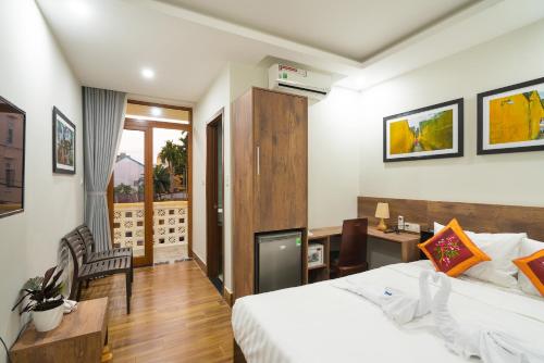 a hotel room with a bed and a desk at The Lit Villa Hoi An in Hoi An