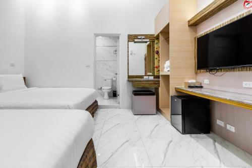 a hotel room with two beds and a flat screen tv at Starry Home in Xiaoliuqiu