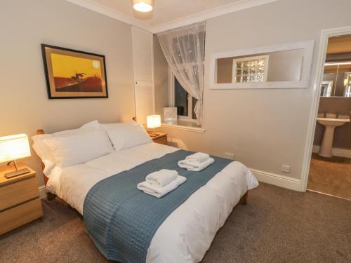 a bedroom with a bed with two towels on it at Seaview Apartment in Barmouth