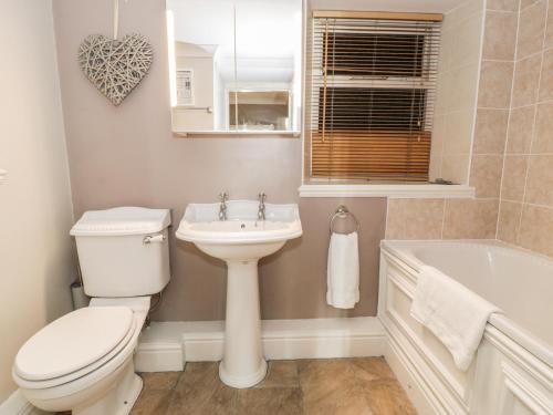 a bathroom with a toilet and a sink and a tub at Seaview Apartment in Barmouth