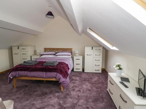 um quarto com uma cama e cómodas num sótão em Butchers Arms Cottage em Llong