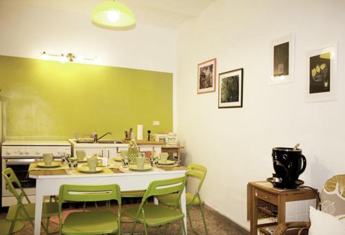 a dining room with a table and green chairs at B&B Il Lauro in Loreto Aprutino