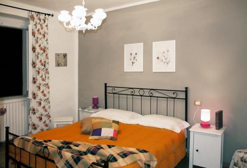 um quarto com uma cama com um cobertor laranja em B&B Il Lauro em Loreto Aprutino