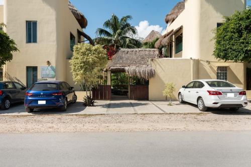 Dos coches aparcados delante de un edificio en Villas Akalan, en Tulum