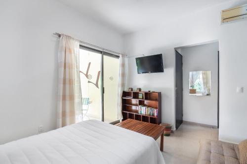 una camera da letto con un letto, una tv e una finestra di Villas Akalan a Tulum