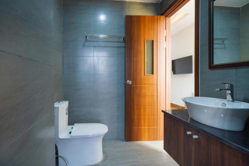 a bathroom with a white toilet and a sink at The Lit Villa Hoi An in Hoi An