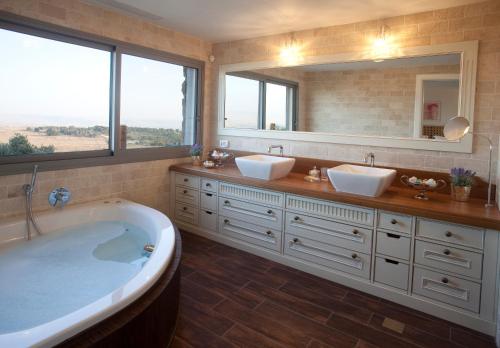 a bathroom with two sinks and a large tub at Boutique Hotel Tamarin in Rosh Pinna