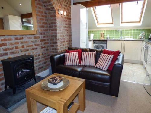 uma sala de estar com um sofá de couro e uma mesa em Bluebird Loft em Coniston