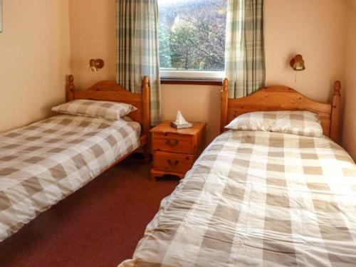 a bedroom with two beds and a window at 5 Innes-Maree in Poolewe