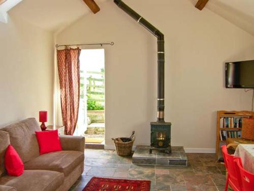 a living room with a couch and a wood stove at Stone Cottage in Mold