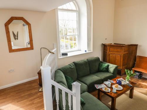 - un salon avec un canapé vert et une table dans l'établissement Thorne Chapel, à Pembroke