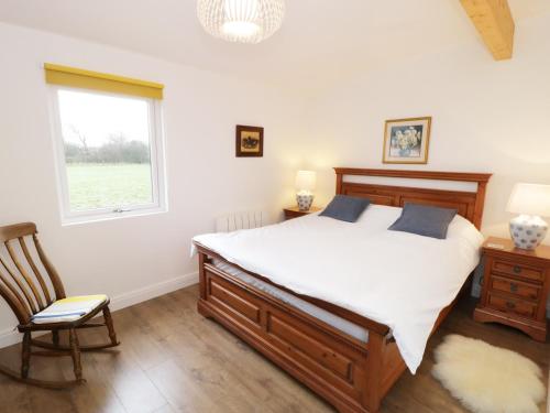 a bedroom with a bed and a window and a chair at The Old Stables in Thornton