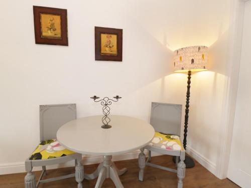 a white table with two chairs and a lamp at The Old Stables in Thornton