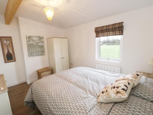 a bedroom with a bed and a window at Foxes Den in Thornton