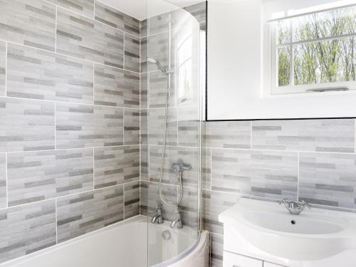 a bathroom with a white tub and a sink at Moor View Chapel in Camelford