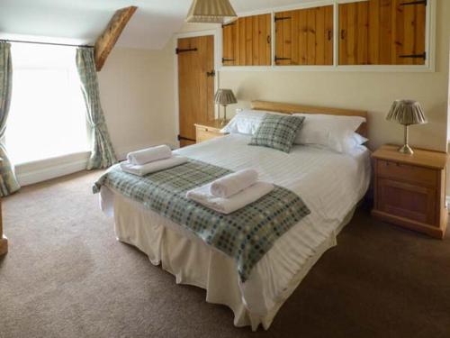 a bedroom with a large bed with two towels on it at Penuwch Fach in Llanfihangel-y-creuddyn
