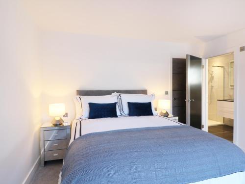 Un dormitorio con una cama grande con almohadas azules. en An Drowes, en Newquay