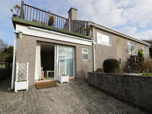 a house with a white door and a balcony at Maesawel Studio in Harlech