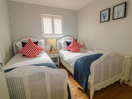 Duas camas com almofadas vermelhas e azuis num quarto em Oh Buoy! em Charlestown