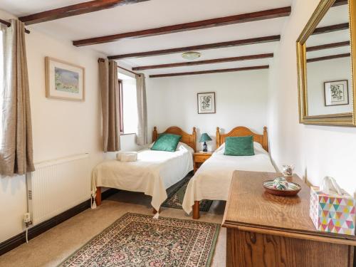 a bedroom with two beds and a table at Brunnion House in Hayle
