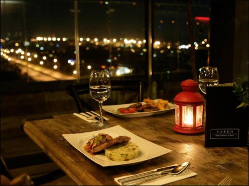 a table with two plates of food and a glass of wine at RYS Hotel in Edirne