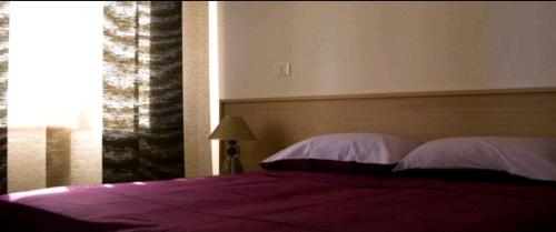 a bedroom with a bed with purple sheets and a window at Casa Augusta in Bibione