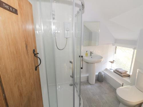 ein Badezimmer mit Dusche, Toilette und Waschbecken in der Unterkunft Bear's Cottage in South Littleton