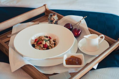 a tray with a bowl of food and a cup of tea at Boutique Hotel Vissi d'Arte in Budva