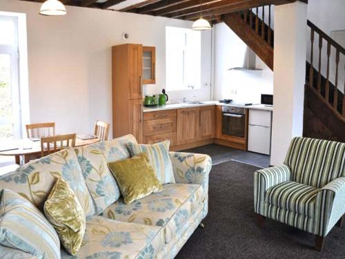 a living room with a couch and a kitchen at Hendre Aled Cottage 3 in Llansannan