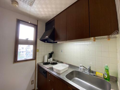 a small kitchen with a sink and a stove at Second Habor Beach House in Naha