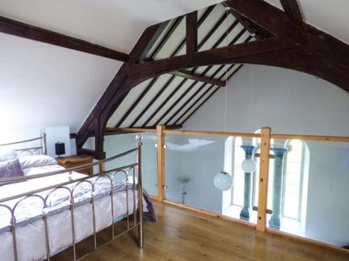 a bedroom with a bed and a large window at Eglwys St Cynfil in Pwllheli