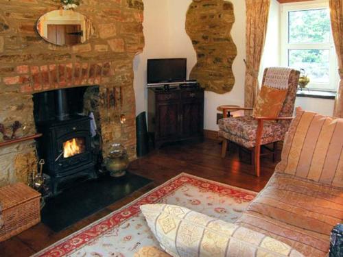 MydrimにあるJohnny's Cottageのリビングルーム(暖炉、ソファ、テレビ付)