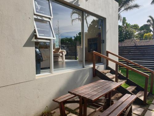 a wooden bench sitting on the side of a house at Amakaya Backpackers Travellers Accommodation in Plettenberg Bay
