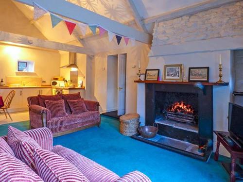 a living room with a couch and a fireplace at The Aylesbury Cottage in Dyrham