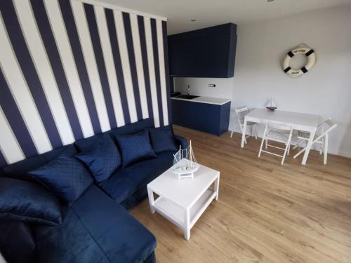 a living room with a blue couch and a table at Przystań na Zagórzu - Apartamenty nad jeziorem in Drezdenko
