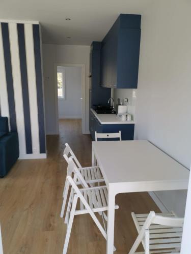 a kitchen with a white table and two chairs at Przystań na Zagórzu - Apartamenty nad jeziorem in Drezdenko
