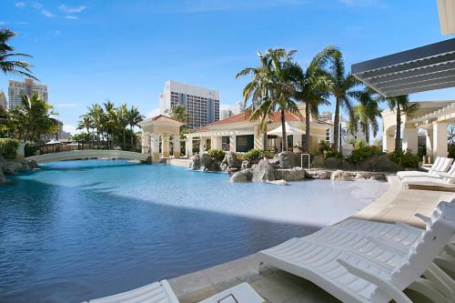 a swimming pool with chaise lounge chairs in a resort at Chevron Renaissance managed by Gchs in Gold Coast